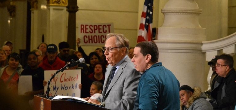 Philadelphia-based attorney Theodore Schwartz, at left, talks at a rally for people with intellectual disabilities. At right is his son, Scott (Brett Sholtis/Transforming Health)
