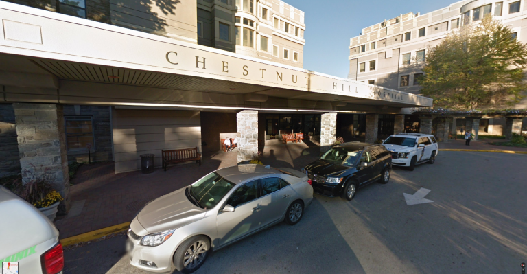 Chestnut Hill Hospital entrance with cars in front of it.