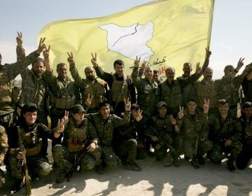 U.S.-backed Syrian Democratic Forces (SDF) fighters pose for a photo in Baghouz, Syria, after the SDF declared the area free of Islamic State militants, in March. (Maya Alleruzzo/AP)