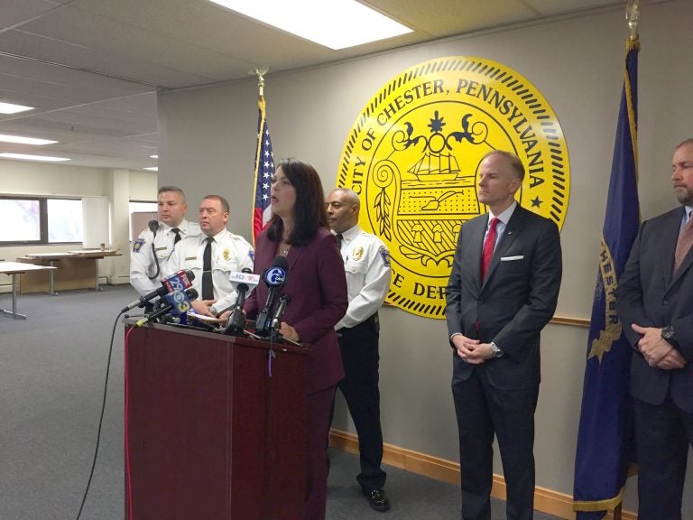 Delaware County District Attorney Katayoun Copeland (center) announces charges against 22 people, all alleged members of two Chester drug gangs. (Avi Wolfman-Arent/WHYY)