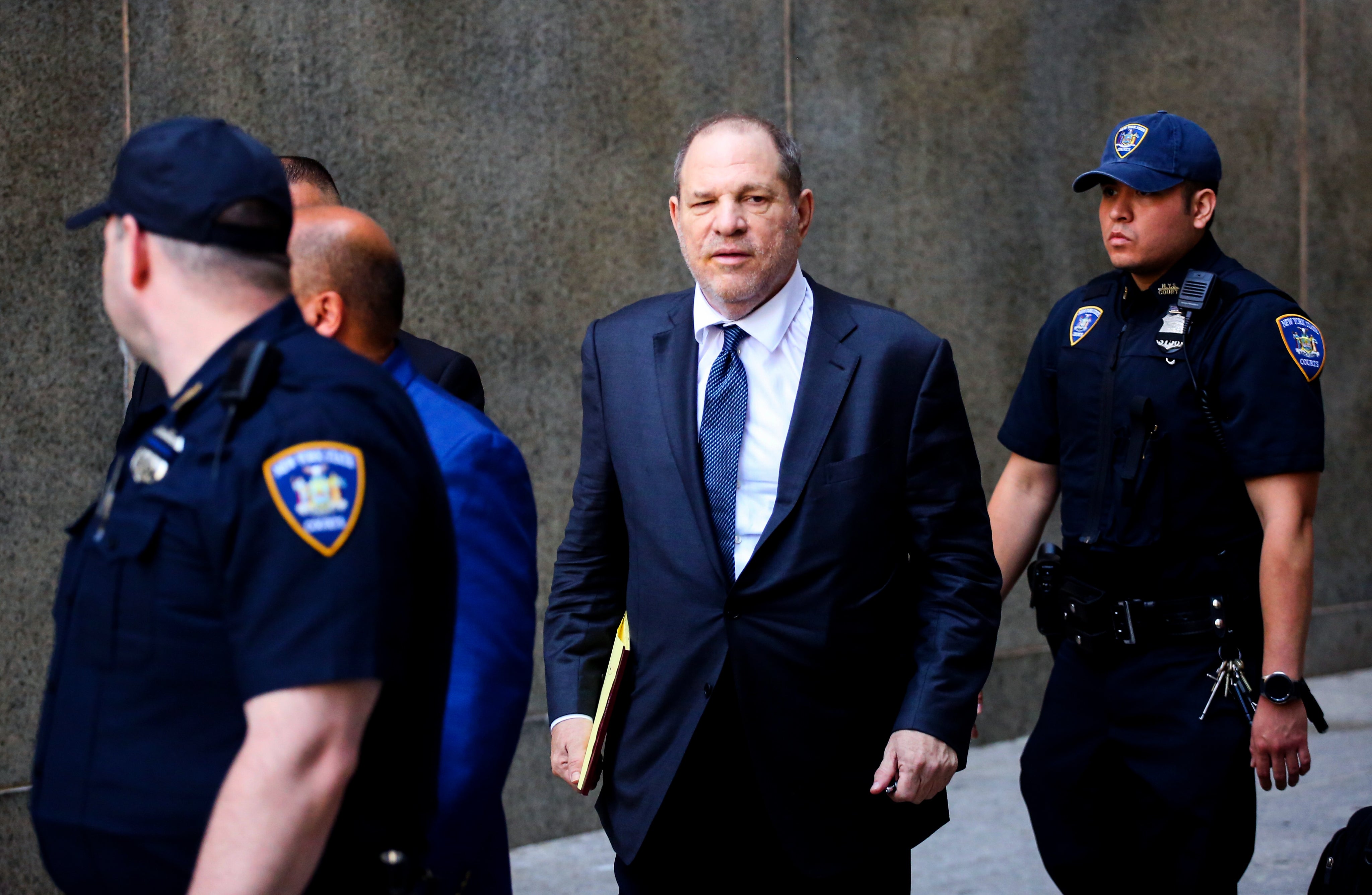 Movie producer Harvey Weinstein (center) leaves the courthouse after appearing in criminal court on sexual assault charges in July in New York City. In his first comments after the scandal broke, he said he was hoping for a "second chance" and "we all make mistakes."