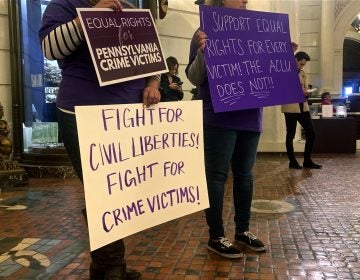 Supporters of Marsy's Law held signs in protest during the ACLU's press conference announcing its lawsuit. (Katie Meyer/WITF)