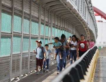 In this June 28, 2019 file photo, local residents with visas walk across the Puerta Mexico international bridge to enter the U.S., in Matamoros, Tamaulipas state, Mexico. (Rebecca Blackwell/AP Photo) 