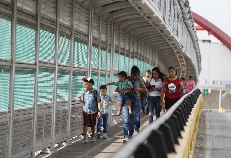 In this June 28, 2019 file photo, local residents with visas walk across the Puerta Mexico international bridge to enter the U.S., in Matamoros, Tamaulipas state, Mexico. (Rebecca Blackwell/AP Photo) 