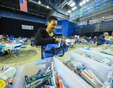 Volunteer Nina Parker packs a duffel full of supplies during Kind to Kids Foundation’s 4th Annual My Blue Duffel Community Service Day. (Saquan Stimpson for WHYY)