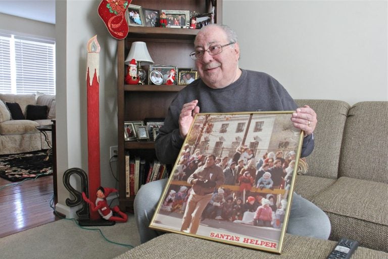 Robert DiBenedetto holds a photo of himself working Philadelphia's Thanksgiving Day Parade in the early 1980s. (Emma Lee/WHYY)