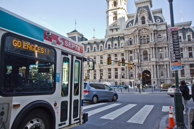 SEPTA buses are given a few seconds ahead of regular traffic to turn, denoted by a vertical white line, at City Hall in Philadelphia. (Kimberly Paynter/WHYY)