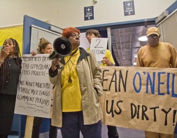 South Philly resident Carol White and other members of Philly Thrive block the entrance to a public meeting about the refinery Thursday evening. (Kimberly Paynter/WHYY)