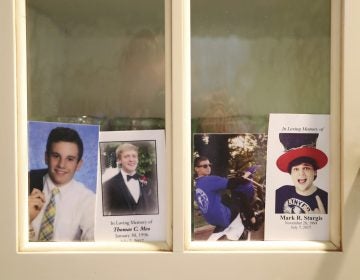 In this Monday, July 2, 2018 photo, four photos, from left, of Jimi Patrick, Tom Meo, Dean Finocchiaro, and Mark Sturgis are placed in a kitchen cabinet window in the home of the grandparents of Patrick, nearing the anniversary of the murders of the four young men in Bucks County in July 2017. Cosmo DiNardo and his cousin Sean Kratz, both 21, were charged in the killings the next day, July 14. (David Swanson/The Philadelphia Inquirer via AP)