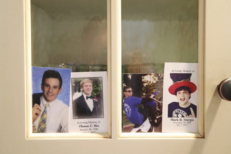 In this Monday, July 2, 2018 photo, four photos, from left, of Jimi Patrick, Tom Meo, Dean Finocchiaro, and Mark Sturgis are placed in a kitchen cabinet window in the home of the grandparents of Patrick, nearing the anniversary of the murders of the four young men in Bucks County in July 2017. Cosmo DiNardo and his cousin Sean Kratz, both 21, were charged in the killings the next day, July 14. (David Swanson/The Philadelphia Inquirer via AP)