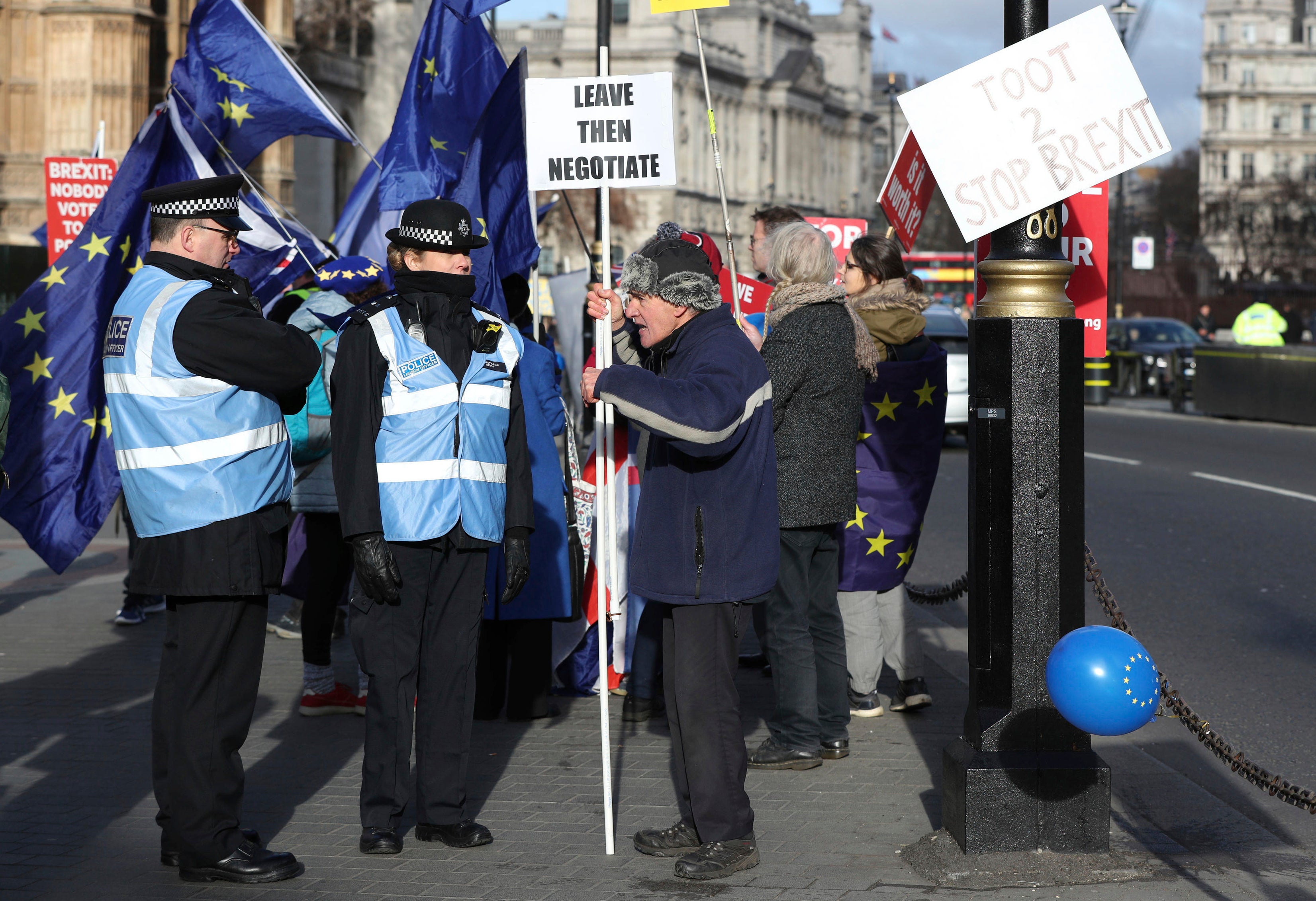 A protester argues with police liaison officers outside Parliament in London, with police briefed to keep law and order in the area, as various Brexit protesters demonstrate in London. Now in the U.K., it's more common to see police liaison officers, who wear blue vests and specialize in communicating with protestors. (Jonathan Brady/PA via AP)