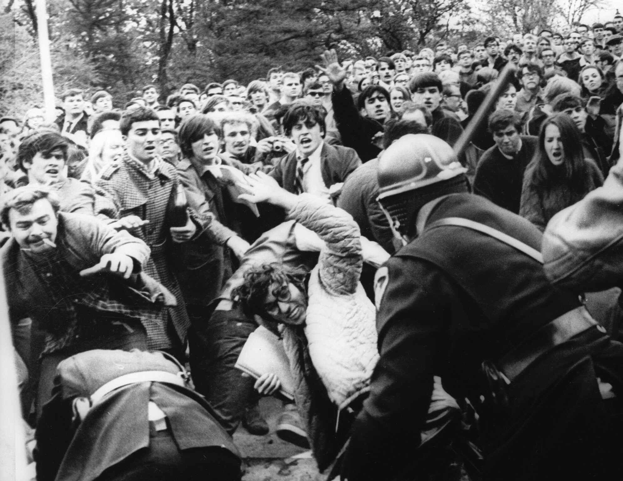 A stick-swinging Madison riot police officer beats back an angry throng of University of Wisconsin protesters, Wednesday, October 19, 1967 on campus. Squads of riot officers broke up a sit-in intended to disrupt the Dow Chemical Company. Dow makes Napalm for the War in Vietnam. (AP Photo)