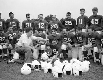 In this July 26, 1939, file photo, Philadelphia Eagles owner and head coach Bert Bell talks to his squad as his son, Bert Bell Jr. sits on a players lap, in Philadelphia. Bell, who later became the league's commissioner, created the NFL draft as a way to assist teams who couldn't attract top talent in the free-for-all system that had been in place. (AP Photo/File)