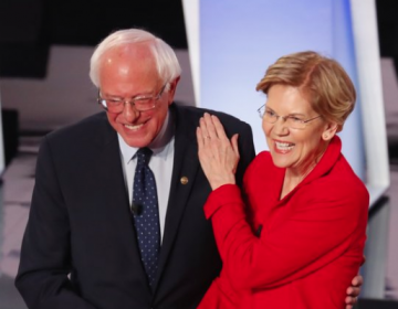 Sen. Bernie Sanders, I-Vt., and Sen. Elizabeth Warren, D-Mass., are proposing to forgive student debt for most Americans. They greet each other at a Democratic primary debate in July. (Paul Sancya/AP Photo)