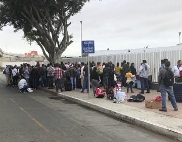 Asylum seekers in Tijuana, Mexico, listen to names being called from a waiting list to claim asylum at a border crossing in San Diego on Sept. 26. (Elliot Spagat/AP Photos)