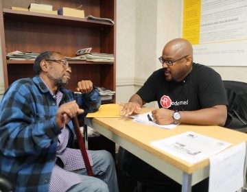 Bill Cobb of Redeemed PA talking with Louis Benson about his right to vote in the Defender Association lobby on Sept. 29, 2016. (David Swanson/The Philadelphia Inquirer) 