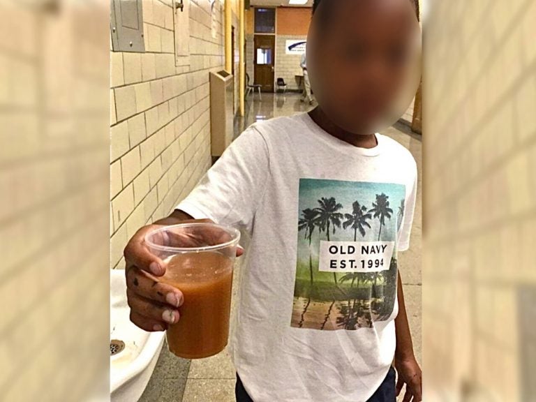 A photo taken by a former teacher at Frederick Douglass Mastery Charter School shows a boy holding a cup of water the teacher said was drawn from a drinking fountain at the school in June of 2016. (Provided)