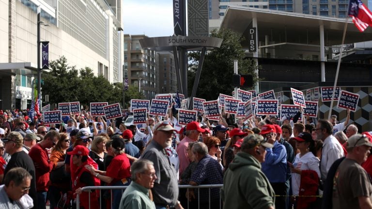 Attendees hold 'We Vape, We Vote' signs ahead of a Trump rally last month in Dallas, Texas. The politics surrounding vaping and industry pushback against regulation appear to have derailed Trump administration's plan to ban the sales of many vaping products.