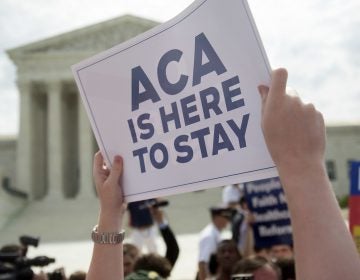 A demonstrator celebrated outside the U.S. Supreme Court in 2015 after the court voted to uphold key tax subsidies that are part of the Affordable Care Act. But federal taxes and other measures designed to pay for the health care the ACA provides have not fared as well. (Andrew Harrer/Bloomberg via Getty Images)