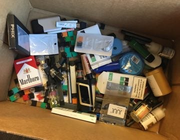 A box of vaping products confiscated from students or thrown away at Boulder High School.  The school's assistant principal collects items for later delivery to the county's hazardous waste facility. (John Daley/Colorado Public Radio)