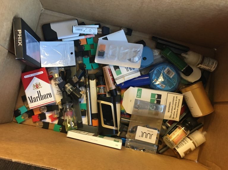 A box of vaping products confiscated from students or thrown away at Boulder High School.  The school's assistant principal collects items for later delivery to the county's hazardous waste facility. (John Daley/Colorado Public Radio)