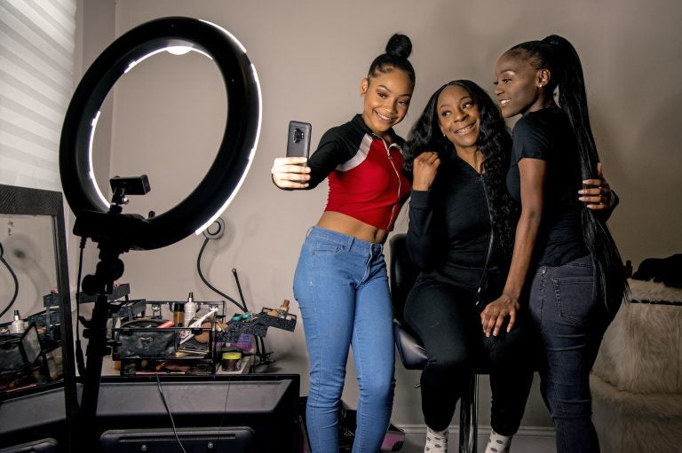 Years ago, Portia Smith (center) suffered postpartum depression and feared seeking care because of child welfare involvement. She and her daughters Shanell Smith (right), 19, and Najai Jones Smith (left), 15, pose for a selfie after makeup artist Najai madeup everyone as they were getting ready at home on Feb. 6, 2019, to go to a movie together. (Tom Gralish/Philadelphia Inquirer)