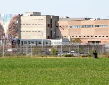 An exterior of a prison is shown, with green grass visible in the foreground.