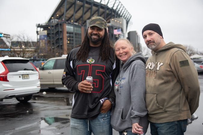 James Whiteside (left) served in the Army from 1993 until 2001. He started coming to the Army-Navy Game when his friends, Danielle and Tom Dologos, gifted him with tickets a few years back. (Emily Cohen for WHYY)