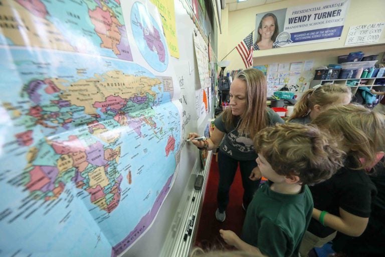 Teacher Wendy Turner writes down notes on the whiteboard during a global awareness session at Mount Pleasant Elementary School in Wilmington. (Saquan Stimpson for WHYY)