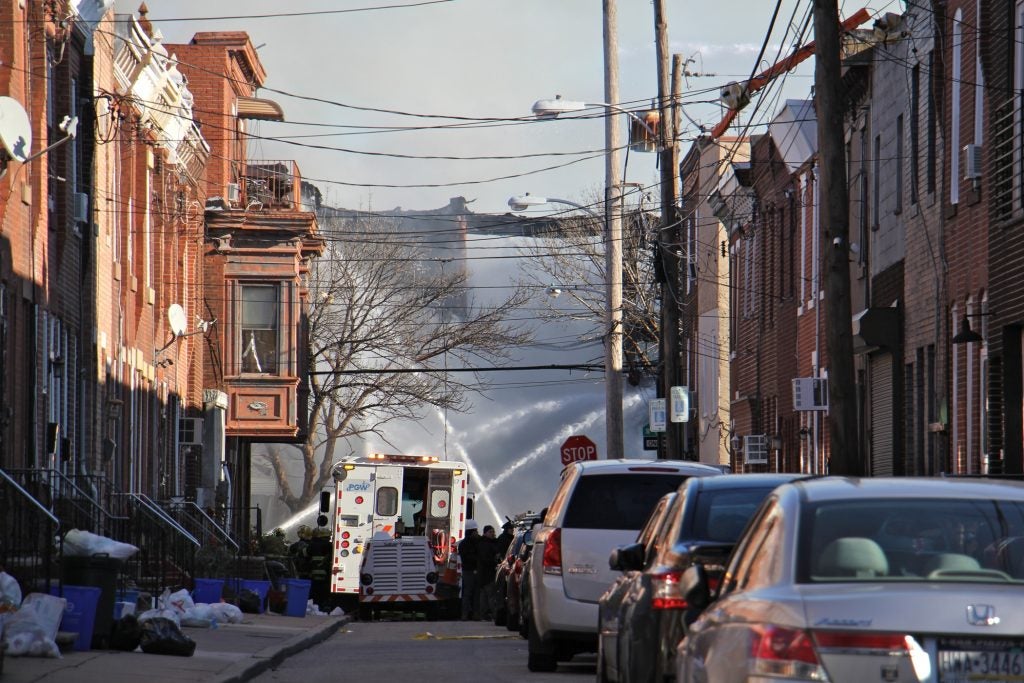 Firefighters hose down the remains of two rowhouses 