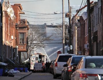 Firefighters hose down the remains of two rowhouses