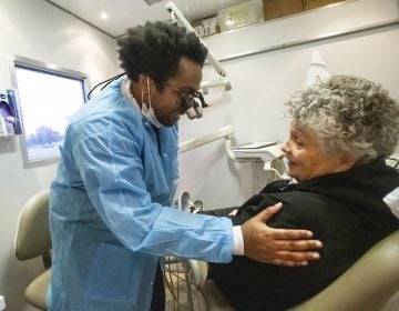 Aspen Dental dentist Dr. David Roberts, left talks to a patient inside the MouthMobile which travels the country  giving free dental care to veterans, in Kennewick, Wash. on Monday, Oct. 21, 2019.