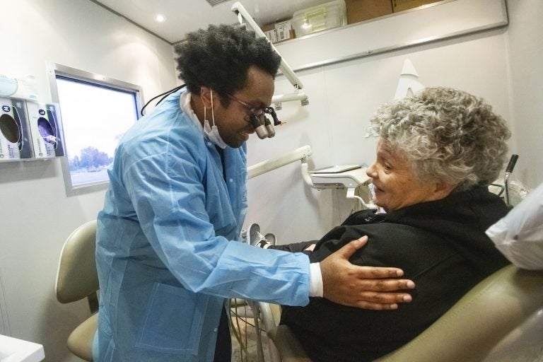 Aspen Dental dentist Dr. David Roberts, left talks to a patient inside the MouthMobile which travels the country  giving free dental care to veterans, in Kennewick, Wash. on Monday, Oct. 21, 2019.
