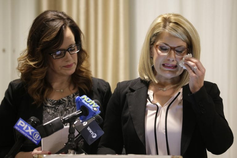 As Patty Fortney-Julius, left, offers support, her sister Lara Fortney McKeever cries as she speaks to reporters during a news conference in Newark, N.J., Monday, Dec. 2, 2019. The two sisters from Pennsylvania are suing the Archdiocese of Newark and the Diocese of Harrisburg, Pennsylvania. They allege clergy in Newark knew a priest had sexually abused children before he moved to Harrisburg and abused them and their sisters for years. Lawsuits alleging sexual abuse by Roman Catholic clergy are taking center stage in New Jersey as the state's relaxation of statute of limitations rules takes effect. (Seth Wenig/AP Photo)