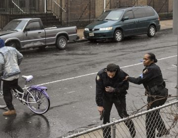 Jersey City police Sgt. Marjorie Jordan, right, helps fellow officer Raymond Sanchez to safety after he was shot during a gunfight that left multiple dead in Jersey City, N.J. (Justin Moreau/AP Photos)