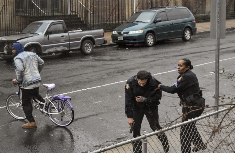 Jersey City police Sgt. Marjorie Jordan, right, helps fellow officer Raymond Sanchez to safety after he was shot during a gunfight that left multiple dead in Jersey City, N.J. (Justin Moreau/AP Photos)