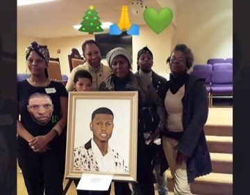 Members of Virgil's family picking up a donated portrait of him this December. (Courtesy of Sandy Ross)