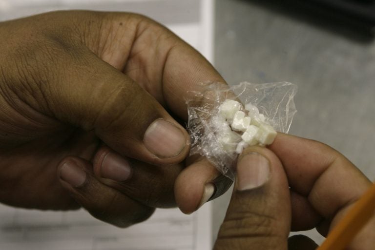 A Los Angeles Police Officer counts the number of doses of Crack cocaine,  as he files an evidence police report Tuesday, Oct. 10, 2006.  (AP Photo/Damian Dovarganes)