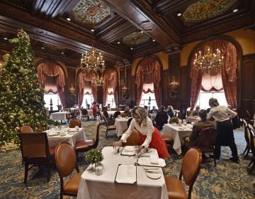 Sheila Marlowe, a hostess at the Green Room for 13 years and counting, sets up a table during lunch on Monday, Dec. 23, 2019, at the Hotel DuPont in downtown Wilmington, Delaware. (Butch Comegys for WHYY)