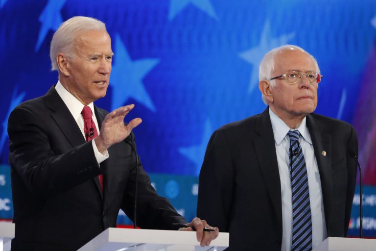 Democratic presidential candidate former Vice President Joe Biden, left, speaks as Democratic presidential candidate Sen. Bernie Sanders, I-Vt., listens during a Democratic presidential primary debate, Wednesday, Nov. 20, 2019, in Atlanta. (AP Photo/John Bazemore)