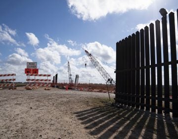 The existing border wall (right) is seen near the construction site of new wall panels south of Donna, Texas. (Verónica G. Cárdenas for NPR)