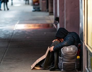 A person sleeps on a sidewalk near New York's Times Square this past week. A new report says more and more American cities are passing laws that make it illegal to sleep outside, on the street, in a park or in your own car. (Jeenah Moon/Getty Images)