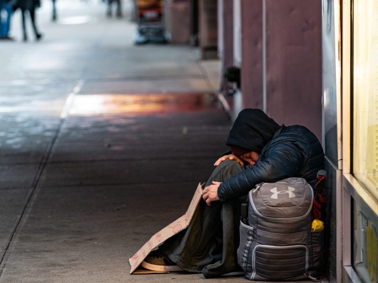 A person sleeps on a sidewalk near New York's Times Square this past week. A new report says more and more American cities are passing laws that make it illegal to sleep outside, on the street, in a park or in your own car. (Jeenah Moon/Getty Images)