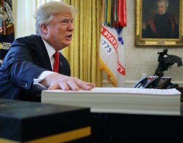 President Trump prepares to sign the tax legislation in the Oval Office on Dec. 22, 2017. The GOP tax cut did not pay for itself, as promised, nor did it deliver a sustained boost to economic growth. (Chip Somodevilla/Getty Images)