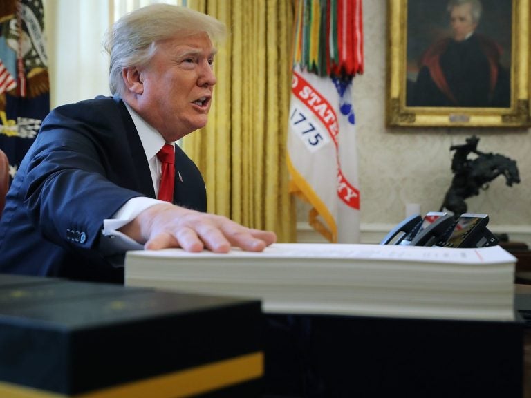 President Trump prepares to sign the tax legislation in the Oval Office on Dec. 22, 2017. The GOP tax cut did not pay for itself, as promised, nor did it deliver a sustained boost to economic growth. (Chip Somodevilla/Getty Images)