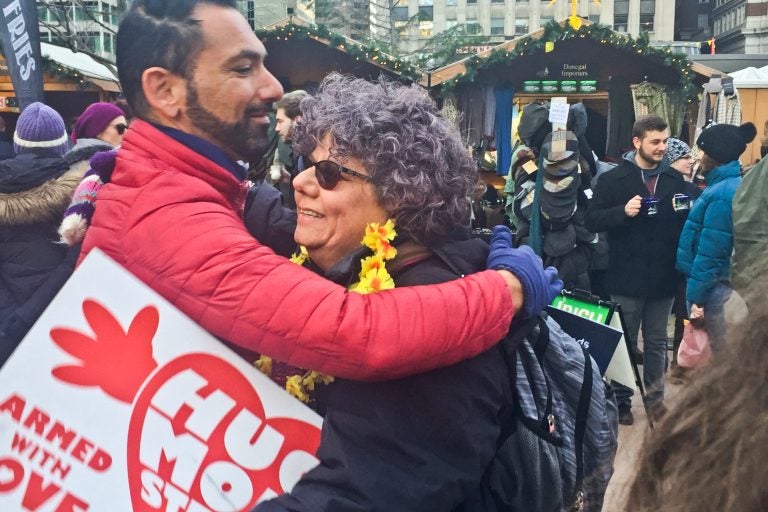 Edie Weinstein gives out hugs at the Christmas Village in Center City. (Annette John-Hall/WHYY)