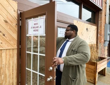 Anthony Hill, Fair Count's communications associate, posts signs encouraging people to use the free Wi-Fi and apply for 2020 census jobs at ARC Community Center in Fort Gaines, Ga. (Hansi Lo Wang/NPR)