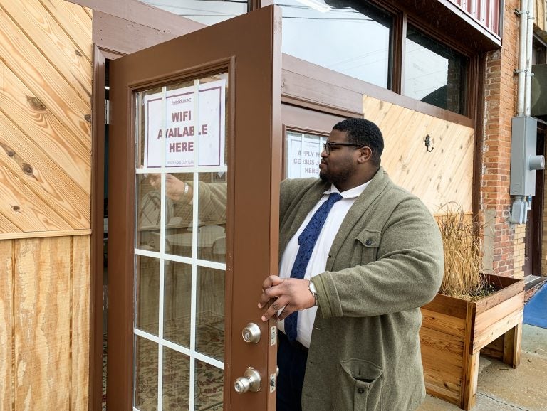 Anthony Hill, Fair Count's communications associate, posts signs encouraging people to use the free Wi-Fi and apply for 2020 census jobs at ARC Community Center in Fort Gaines, Ga. (Hansi Lo Wang/NPR)