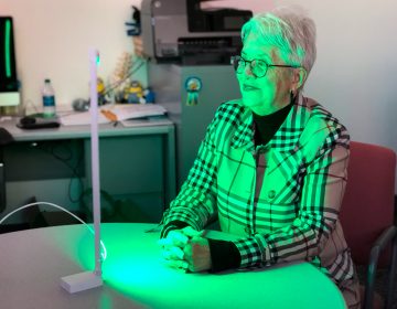 Ann Jones has been spending two hours each day in front of a green LED light — an experimental treatment aimed at alleviating migraines and other forms of chronic pain. (Will Stone for NPR)