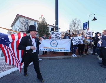 Jack Schreppler, Hummers Parade 'Grand Marshal for life' walks past protesters after greeting them during the Hummers Parade. (Saquan Stimpson for WHYY)